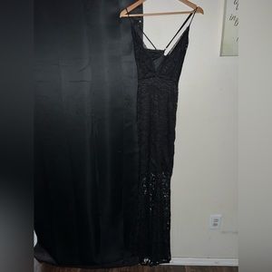 Long black dress, covered down to the knees then is visible